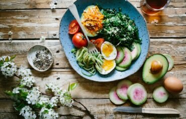poached egg with vegetables and tomatoes on blue plate